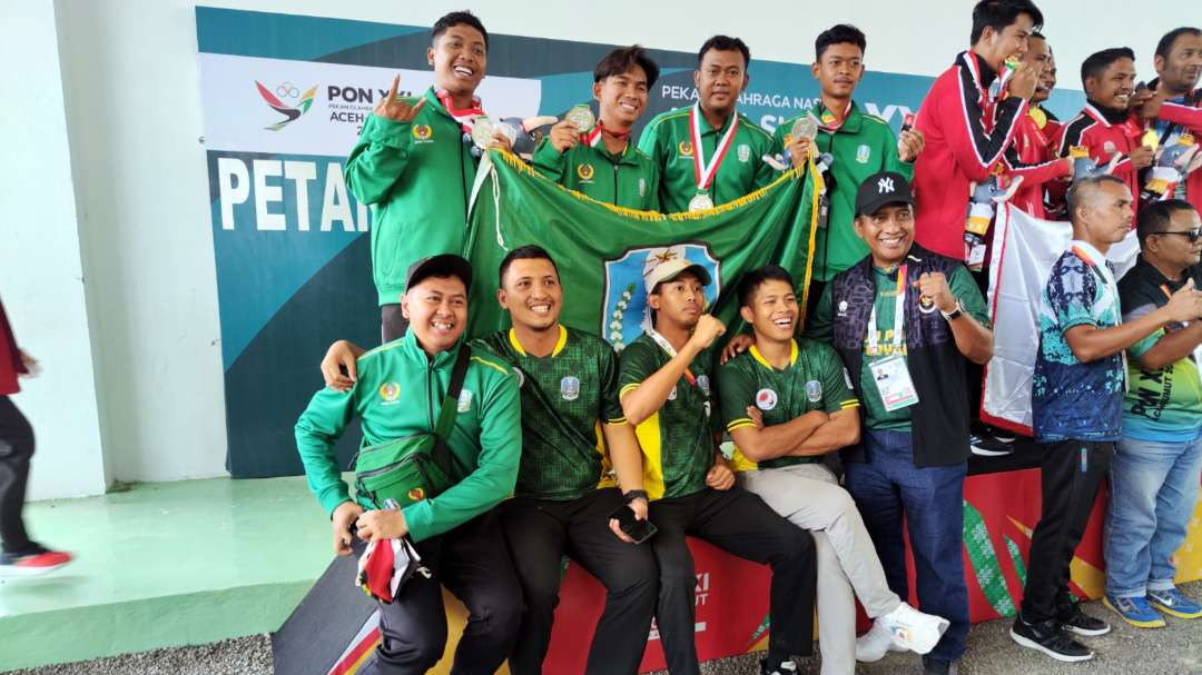 Ketua FOPI, Prof Nurhasan (kanan) bersama dengan tim beregu putra Jatim usai upacara penghormatan pemenang PON XXI 2024 Aceh-Sumut. (Foto: Fariz Yarbo/Ngopibareng.id)