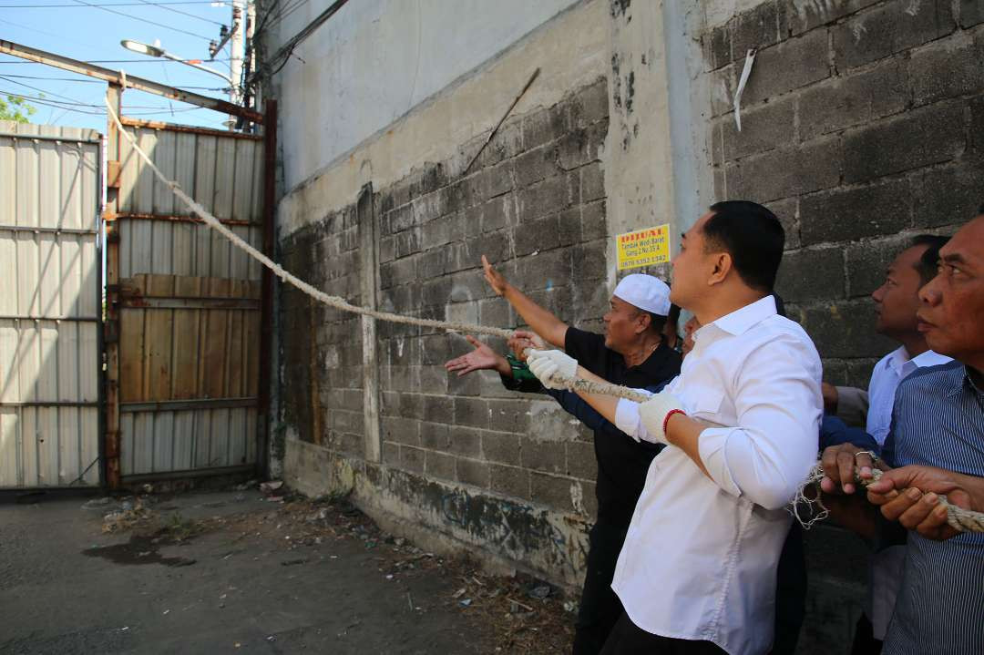 Walikota Surabaya Eri Cahyadi bersama warga setempat, saat membongkar tembok yang menutupi badan Jalan Tambak Wedi Baru, Kenjeran. (Foto: Humas Pemkot Surabaya)