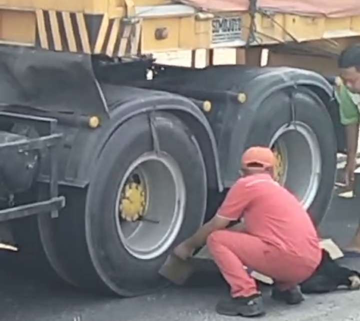 Sebelum dievakuasi, warga berusaha menutupi jenazah korban terlindas truk. (Foto: Istimewa)