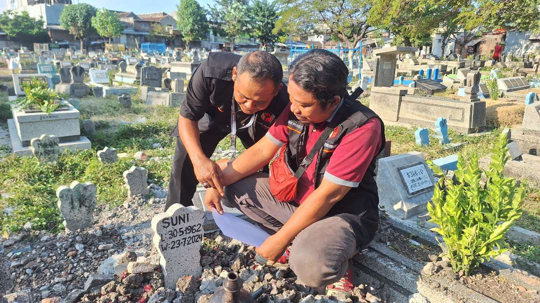 Petugas Panitia Pengawas Pemilu Kecamatan (Panwascam) Sawahan, saat melakukan pengecekan data pemilih yang sudah tutup usia, tapi masih masuk dalam DPS di TPU Putat Gede, Sawahan. (Foto: Julianus Palermo/Ngopibareng.id)