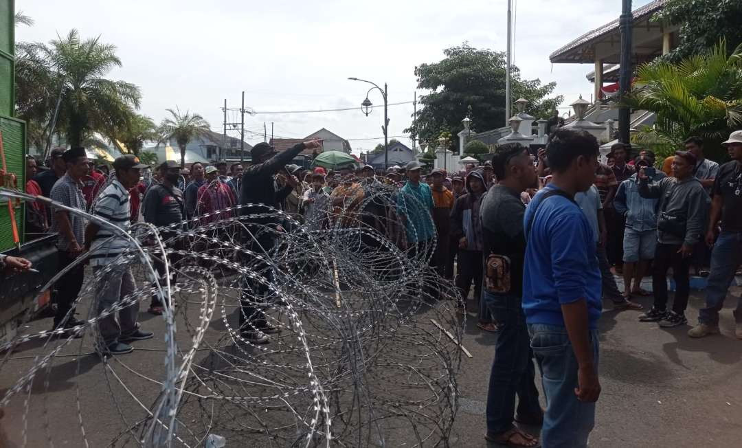 Ratusan buruh Perumda Kahyangan Jember saat melakukan aksi unjuk rasa di depan Pendapa Bupati Jember (Foto: Rusdi/Ngopibareng.id)