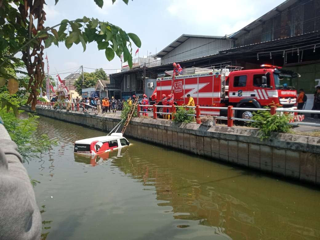 Sebuah angkutan feeder Wira-Wiri Surabaya yang tercebur di sungai kawasan Jalan Medokan Sawah, Rungkut, Surabaya, Kamis 19 September 2024. (Foto: Istimewa)