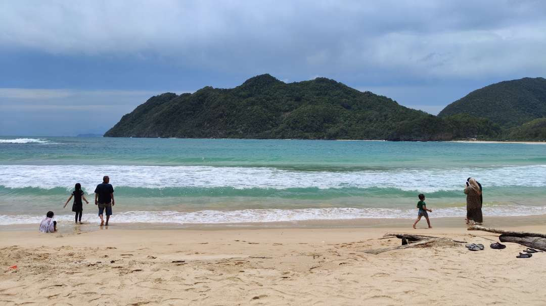 Keindahan Pantai Lampuuk dengan latar belakang bukit hijau. (Foto: Fariz Yarbo/Ngopibareng.id)