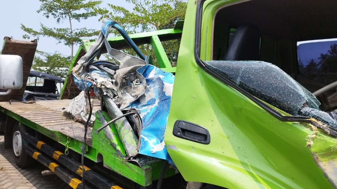 Salah satu bagian kendaraan travel masih menyangkut pada truk towing (Foto : Muh Hujaini/Ngopibareng.id)