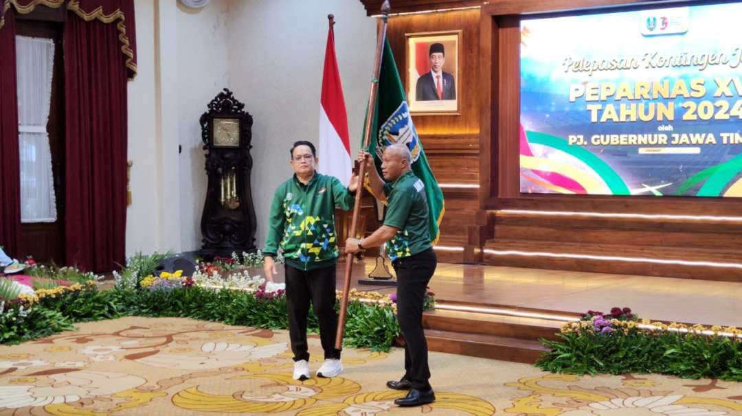 Pj Gubernur Jatim, Adhy Karyono saat menyerahkan bendera pataka kepada Ketua NPC Jatim Imam Kuncoro pada pelepasan kontingen Jatim ke Peparnas 2024 di Gedung Negara Grahadi, Surabaya, Senin 30 September 2024. (Foto: Fariz Yarbo/Ngopibareng.id)