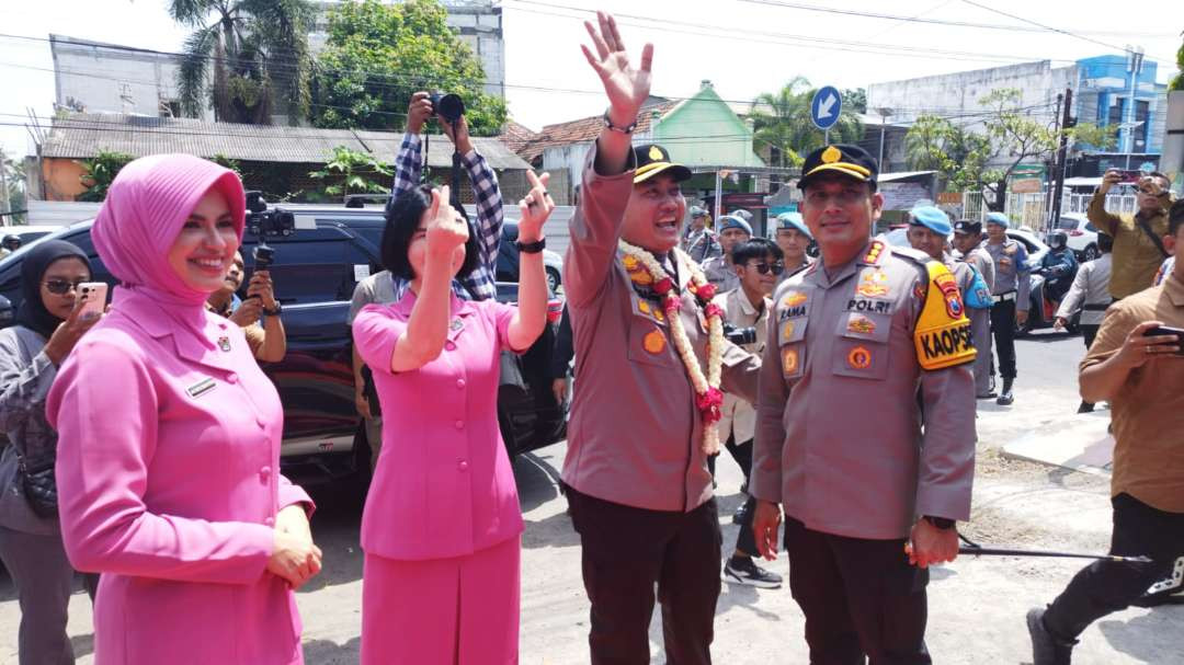 Kombespol Nanang Haryono melambaikan tangan di akhir farewell parade didampingi Kapolresta Banyuwangi yang baru Kombespol Rama Samtama Putra. (Foto: Muh Hujaini/Ngopibareng.id)