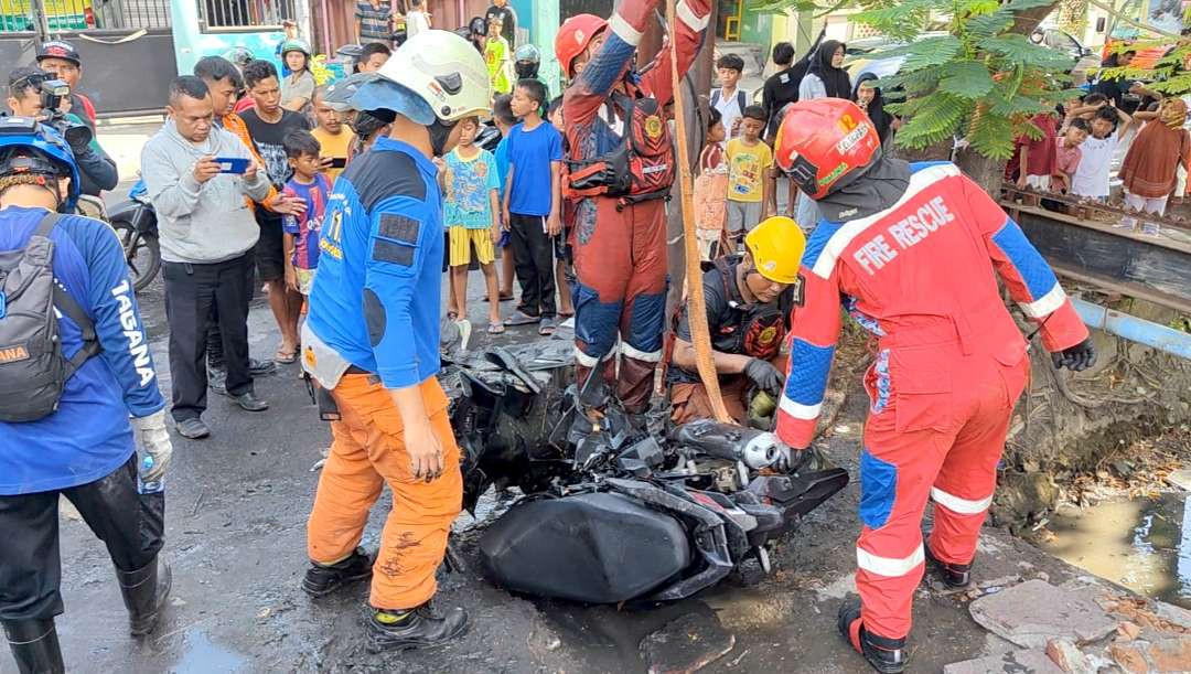 Petugas saat mengevakuasi sepeda motor dari dalam sungai. (Foto: Fariz Yarbo/Ngopibareng.id)