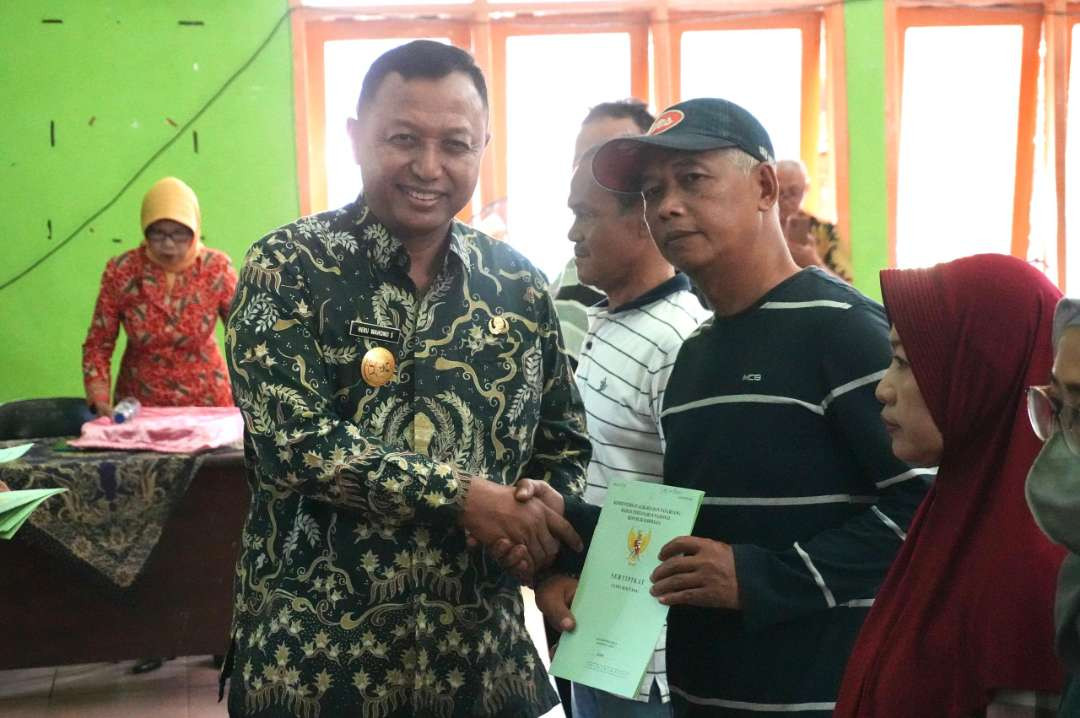 Pemerintah Kabupaten Kediri melalui Penjabat Sementara (Pjs) Bupati Heru Wahono Santoso menyalurkan sertifikat tanah dalam Program Pendaftaran Tanah (Foto: istimewa)