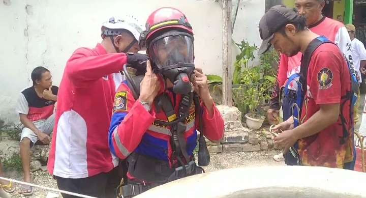 Petugas Damkar Tuban saat melakukan upaya evakuasi emseekor ayam yang terjebur ke dalam sumur (Foto: Khoirul Huda/Ngopibareng.id)