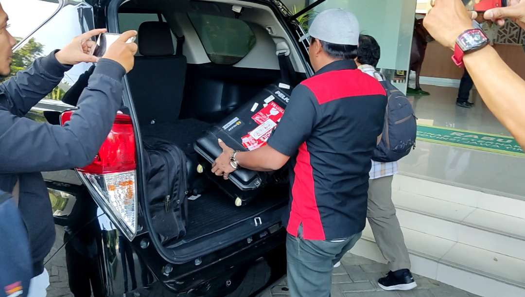 Penyidik KPK membawa sebuah koper usai penggeledahan di Kantor Dinas Peternakan Jatim, Surabaya, Rabu 16 Oktober 2024. (Foto: Fariz Yarbo/Ngopibareng.id)