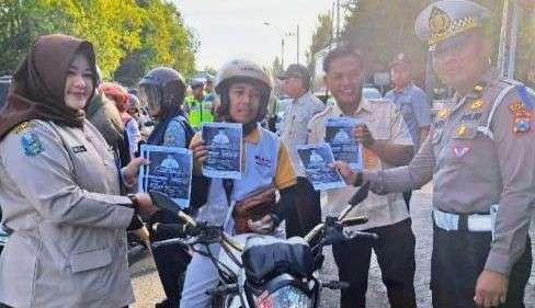 Anggota Satlantas Polres Situbondo sosialisasi dan edukasi aturan lalu lintas dengan membagikan brosur kepada pengendara di jalan raya. (Foto: Polres Situbondo)