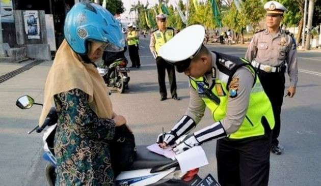 Anggota Satlantas Polres Bondowoso melakukan penindakan tilang di tempat pada pengendara motor melanggar aturan lalu lintas.(Foto: Guido/Ngopibareng.id)