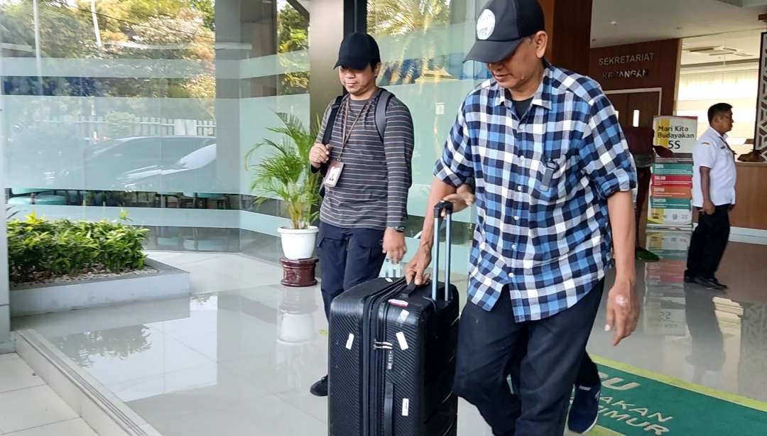 Penyidik membawa satu koper besar usai penggeledahan di Kantor Dinas Peternakan Jatim, Surabaya, Rabu 16 Oktober 2024. (Foto: Fariz Yarbo/Ngopibareng.id)