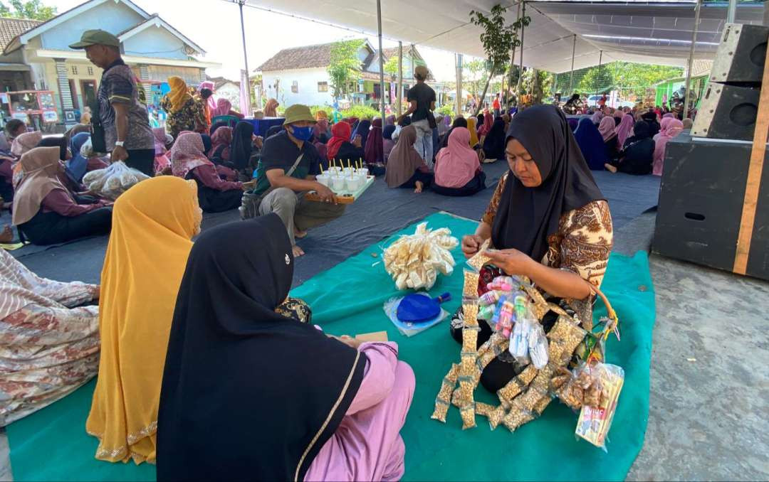 Tumirah, sedang menawarkan dagangannya kepada peserta kampanye Gus Fawait, di Desa Jambearum, Kecamatan Puger (Foto: Dokumentasi tim Gus Fawait)