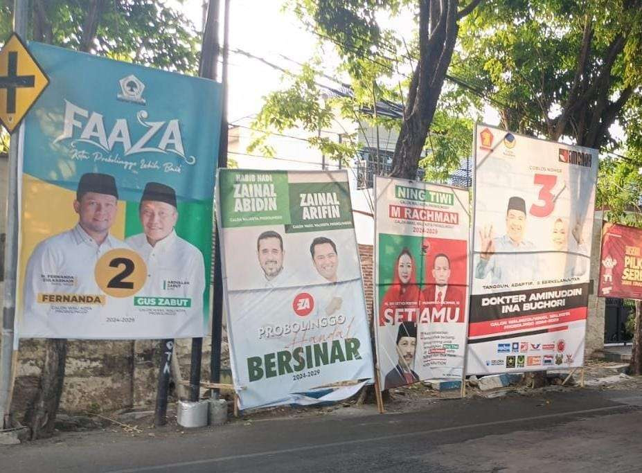 Sejumlah APK di Jalan Pahlawan selain tidak boleh dipasang di jalan protokol, juga melanggar karena dipaku di pohon. (Foto: Ikhsan Mahmudi/Ngopibareng.id)