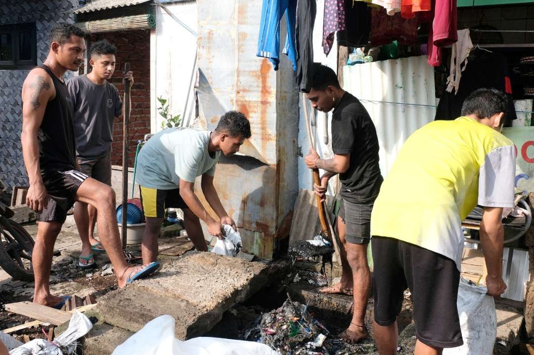 Para warga sedang bergotong-royong melakukan kerja bakti, membersihkan saluran di daerah perkampungan Kota Surabaya. (Foto: Humas Pemkot Surabaya)