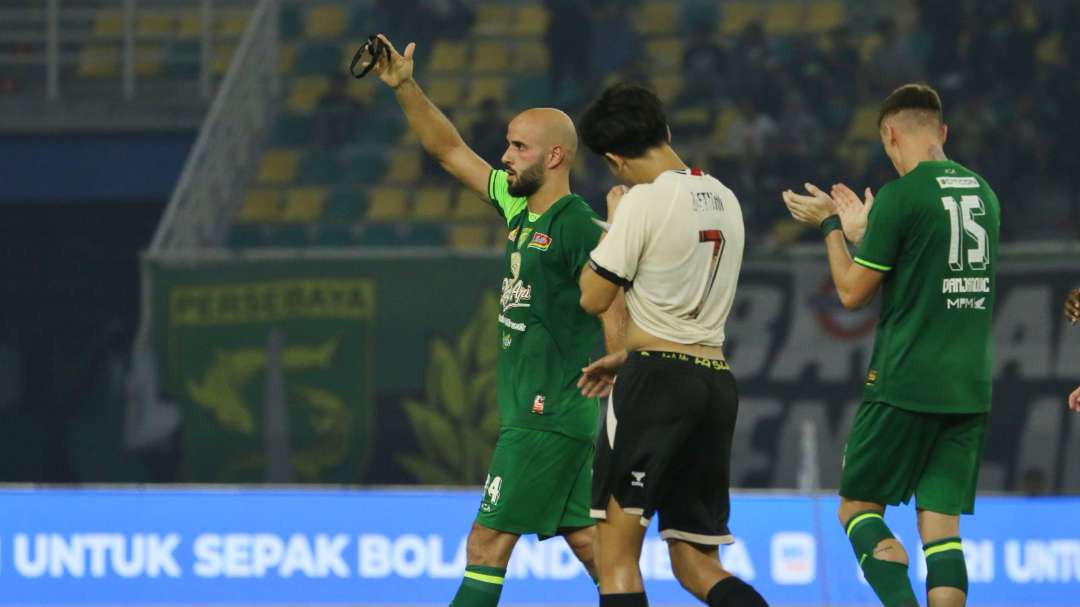 Pemain Persebaya, Moh Rashid melakukan selebrasi memegang pita hitam sebagai bentuk penghormatan atas meninggalnya Rudy Keltjes dalam laga Persebaya melawan PSM di Stadion Gelora Bung Tomo, Surabaya, Rabu 23 Oktober 2024. (Foto: Fariz Yarbo/Ngopibareng.id)