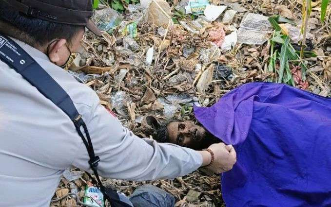 Anggota Polsek Panarukan Situbondo memeriksa kondisi pria ODGJ tanpa identitas meninggal di lahan tanaman jagung.(Foto: Polsek Panarukan)