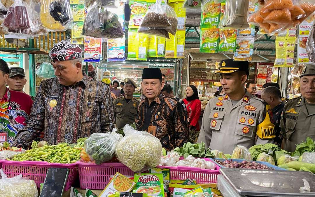 Pjs Bupati Situbondo Aftabuddin Rijaluzzaman didampingi Sekda Wawan Setiawan dan Wakapolres Kompol Made Prawira mengecek bahan pokok di pasar tradisional Situbondo. (Foto: Guido Saphan/Ngopibareng.id)