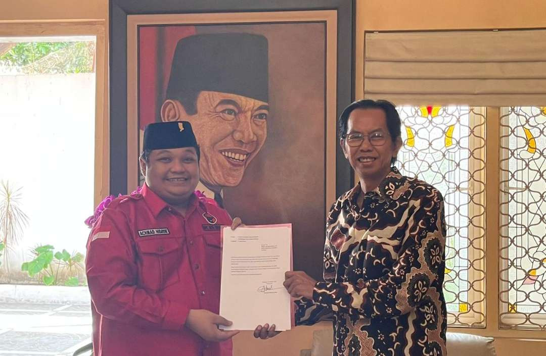 Wakil Sekretaris DPC PDI Perjuangan Kota Surabaya Achmad Hidayat saat menyerahkan usulan perda perlindungan hukum bagi segenap guru di Kota Surabaya kepada Ketua DPRD Kota Surabaya Adi Sutarwijono. (Foto: Julianus Palermo/Ngopibareng.id)