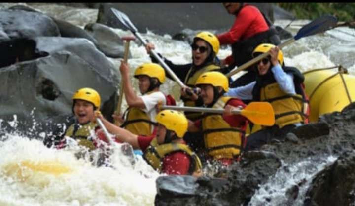 Peserta arung jeram berjuang keras untuk melepaskan perahu dari jepitan batu dan derasnya arus Sungai Cisadane. (Foto: Alamanda)