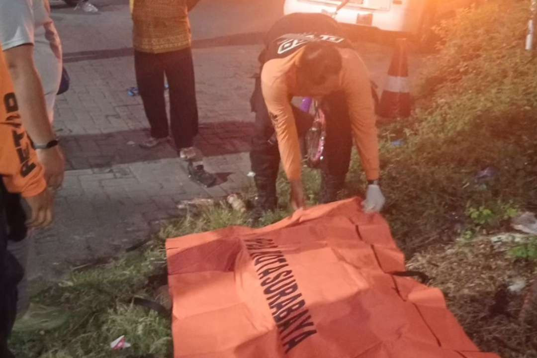 Petugas BPBD Kota Surabaya saat mengevakuasi pria tanpa identitas yang tewas diamuk warga setelah ketahuan mencuri sepeda angin. (Foto: BPBD Kota Surabaya)