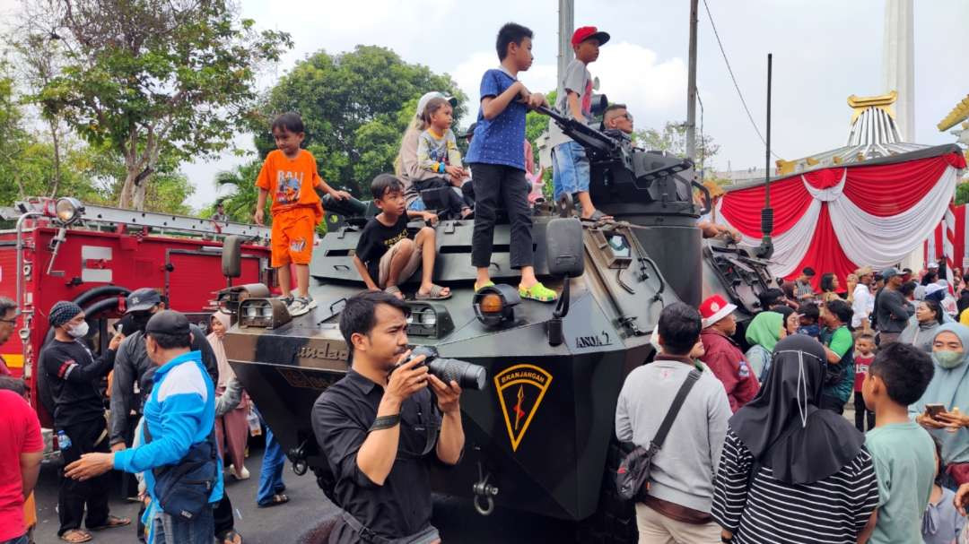 Sejumlah anak-anak menaiki kendaraan taktis milik TNI dalam upacara Hari Pahlawan di Tugu Pahlawan, Surabaya, Minggu 10 November 2024. (Foto: Fariz Yarbo/Ngopibareng.id)