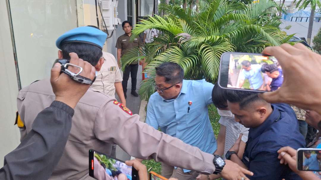 Tersangka IV saat digelandang ke Ruang Pelayanan Khusus Polrestabes Surabaya saat hendak menjalani pemeriksaan, Kamis 14 November 2024. (Foto: Julianus Palermo/Ngopibareng.id)