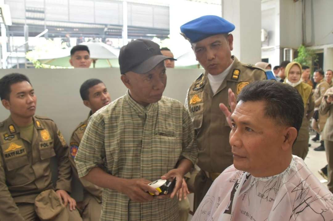 Warga saat memangkas rambut di lantai 1 Gedung Satpol PP Kota Surabaya, Jalan Jaksa Agung Suprapto, Surabaya. (Foto: Humas Pemkot Surabaya)