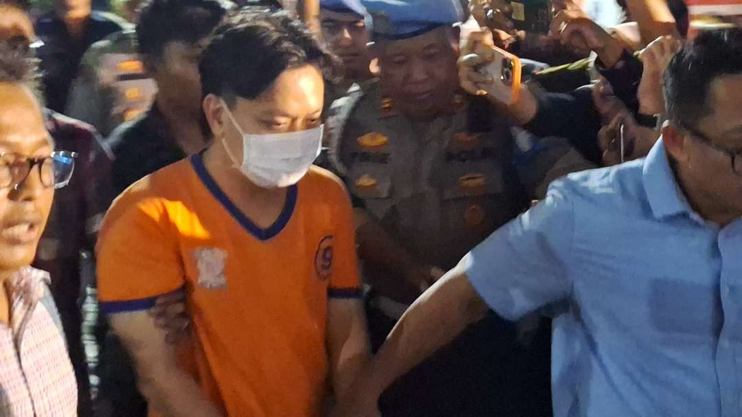 Ivan Sugiamto atau IV, tersangka kasus perundungan terhadap siswa SMA Kristen Gloria 2 Surabaya saat hendak digelandang polisi ke tahanan Polrestabes Surabaya. (Foto: Julianus Palermo/Ngopibareng.id)