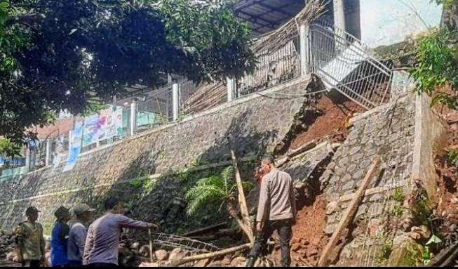 Anggota Polsek Sumbermalang Situbondo mengidentifikasi plengsengan Kantor Desa Baderan memakan korban meninggal dunia tukang bangunan.(Foto: Polsek Sumbermalang )