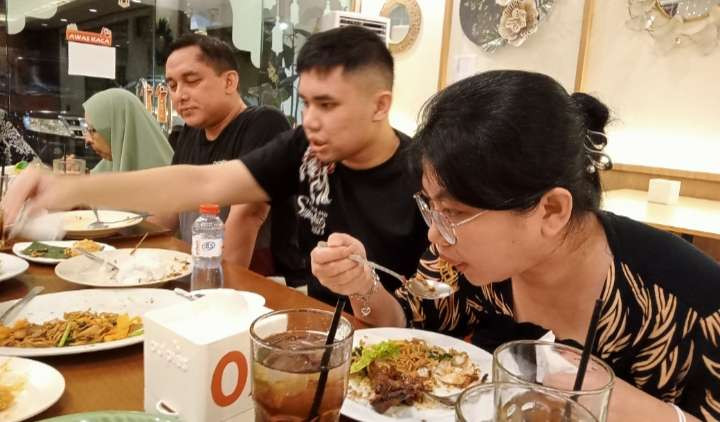 Pelanggan gulai paku Uni Dea, tengah menikmati lezatnya salah satu kuliner favorit khas Sumatera Barat ini. (Foto: Asmanu Sudarso/Ngopibareng.id)