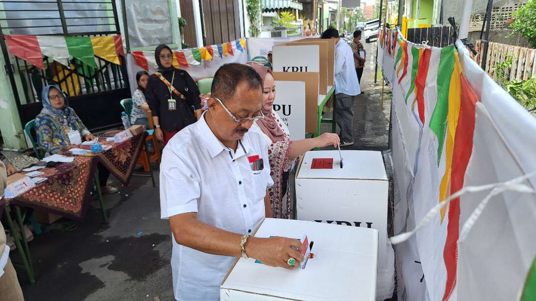 Wakil Walikota Surabaya Armuji bersama istrinya, Iswahyurini saat memasukkan surat suara ke kotak suara setelah melakukan pencoblosan di TPS 17, Kelurahan Ngagelrejo, Kecamatan Wonokromo, Surabaya. (Foto: Julianus Palermo/Ngopibareng.id)