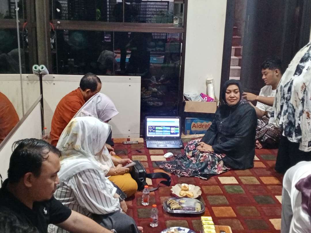 Keluarga Yuhronur memantau hitung cepat dengan menggunakan laptop. (Foto Imron Rosidi/ngopibareng.id)