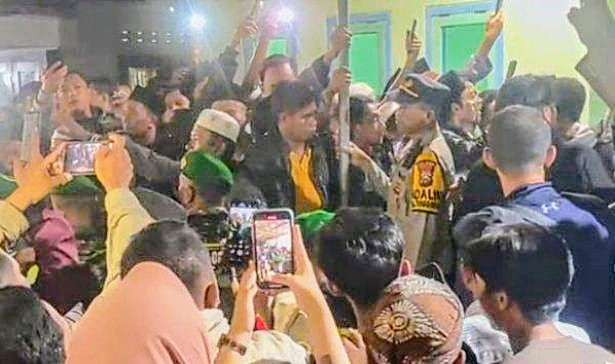 Aparat keamanan mengamankan anggota KPPS TPS 03 Desa Kesemek Tenggarang dari serbuan warga setelah ditemukan pelanggaran pemungutan suara Pilkada Bondowoso 2024.(Foto: Tangkapan Layar)