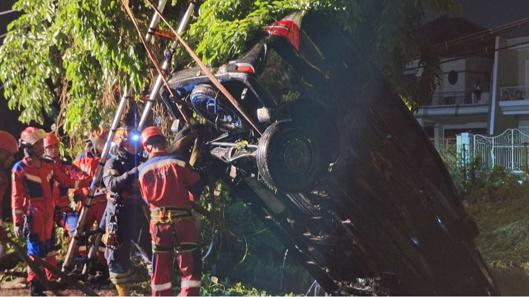 Petugas DPKP Surabaya saat mengevakuasi mobil Toyota Avanza milik warga Karang Menjangan, Wawan Dwi Hartono, yang tercebur di sungai dekat Dharmahusada Indah Blok F, Jumat 29 November 2024. (Foto: Julianus Palermo/Ngopibareng.id)