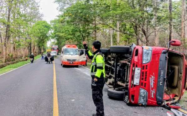 Anggota Satlantas Polres Situbondo mengamankan minibus Isuzu Elf terguling di Jajan Raya Hutan Baluran, Kecamatan Banyuputih.(Foto: Satlantas Polres Situbondo)