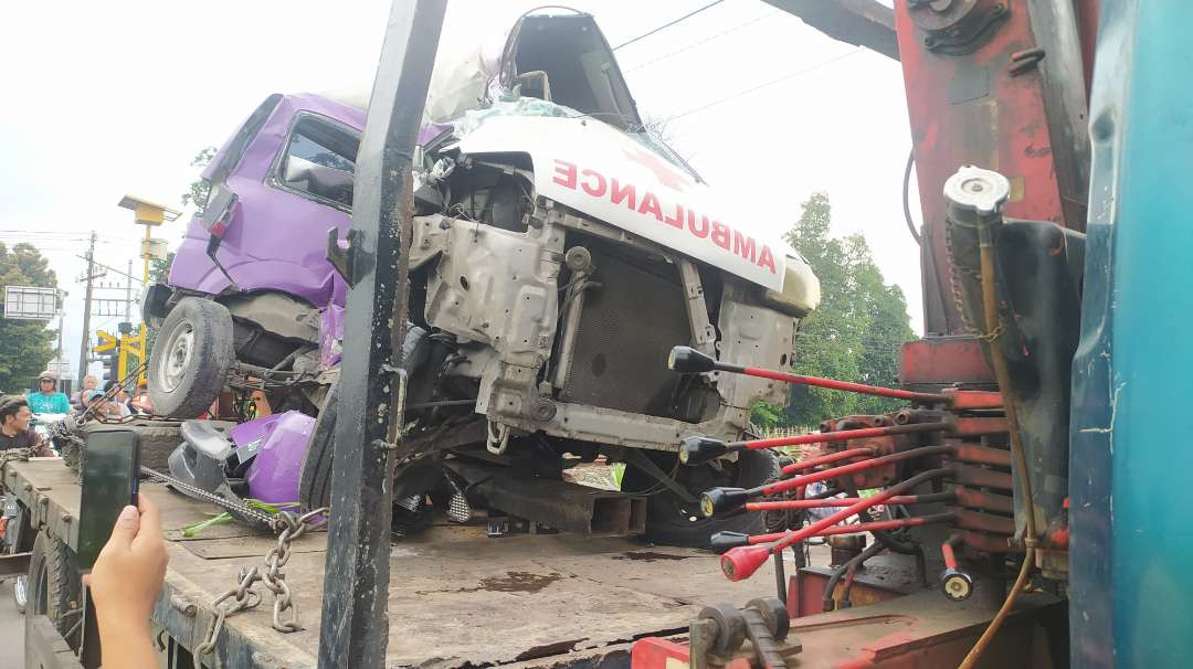 Ambulans RSUD Gambiran Kota Kediri dievakuasi oleh petugas dari lokasi kecelakaan. (Foto: Fendi Lesmana/Ngopibareng.idd)