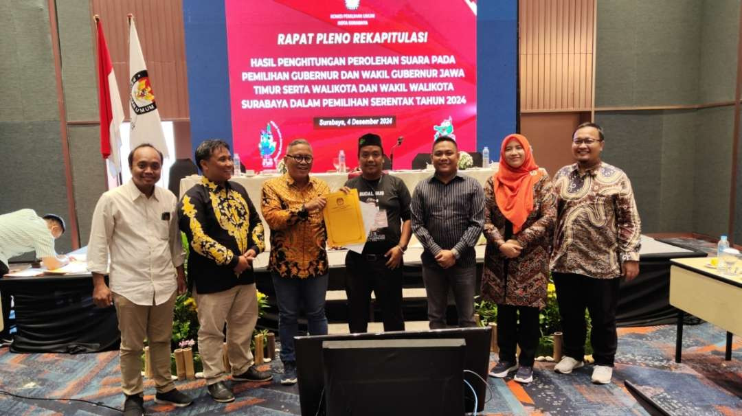 Komisioner KPU Surabaya menyerahkan hasil rekapitulasi kepada tim pemenangan paslon usai rekapitulasi suara di Surabaya, Rabu 4 Desember 2024. (Foto: Fariz Yarbo/Ngopibareng.id)