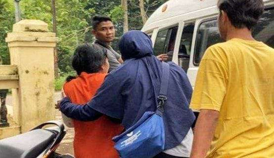 Perempuan pelaku pembacokan (baju orange) suami dan mertuanya saat diamankan anggota Unit PPA Satreskrim Polres Bondowoso dan Polsek Pakem.(Foto: Humas Polres Bondowoso)