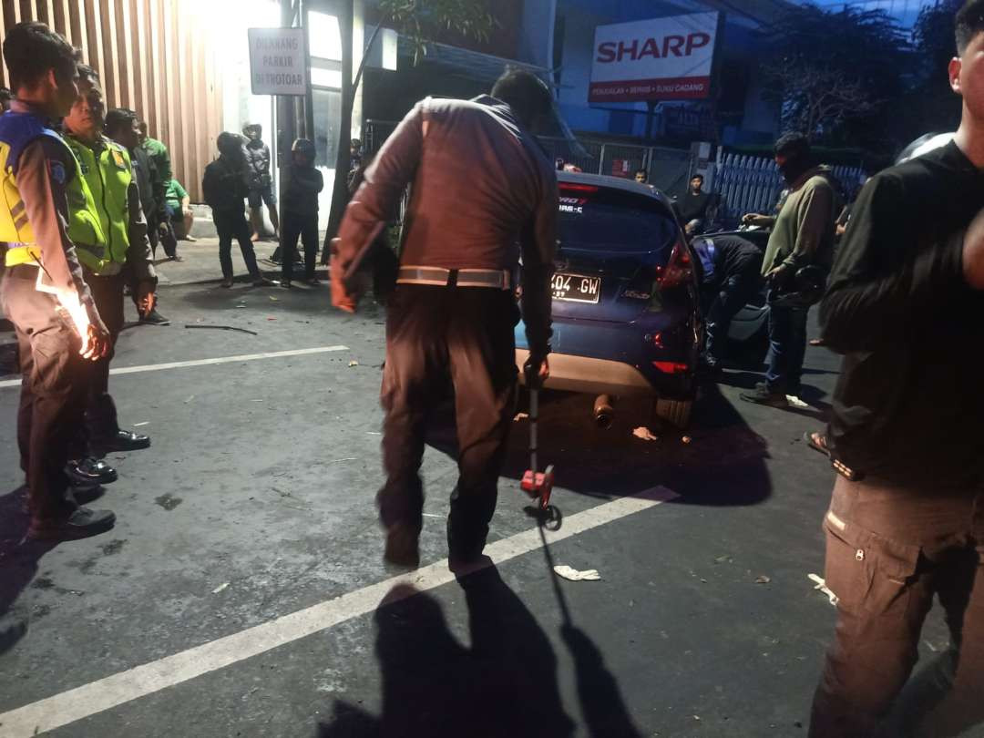 Unit Laka Satlantas Polrestabes Surabaya saat melakukan olah TKP di lokasi kejadian kecelakaan yang melibatkan mobil Ford Fiesta dan gerobak sampah di Jalan Kertajaya Indah. (Foto: Polrestabes Surabaya)