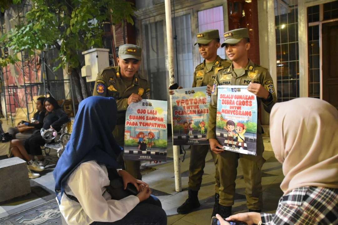 Petugas Satpol PP Kota Surabaya sosialisasi larangan menggunakan trotoar selain daripada kepentingan pejalan kaki di kawasan Jalan Tunjungan. (Foto: Humas Pemkot Surabaya)