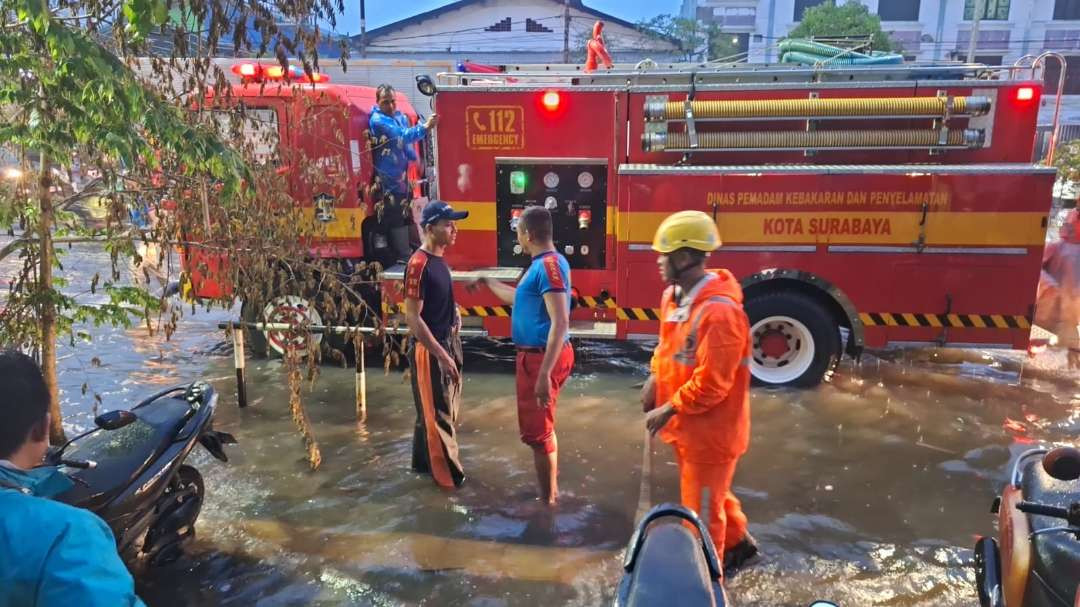 Petugas Dinas Pemadam Kebakaran dan Penyelamatan (DPKP) Kota Surabaya saat memompa genangan air di salah satu ruas jalan di Kota Surabaya. (Foto: Julianus Palermo/Ngopibareng.id)