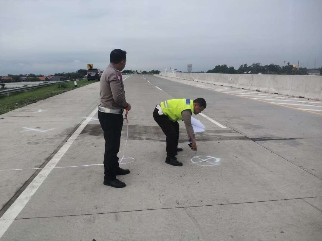 Polisi melakukan olah tempat kejadian perkara (TKP) tewasnya pelatih kepala Persewangi di Tol Paspro. (Foto: Ikhsan Mahmudi/Ngopibareng.id)