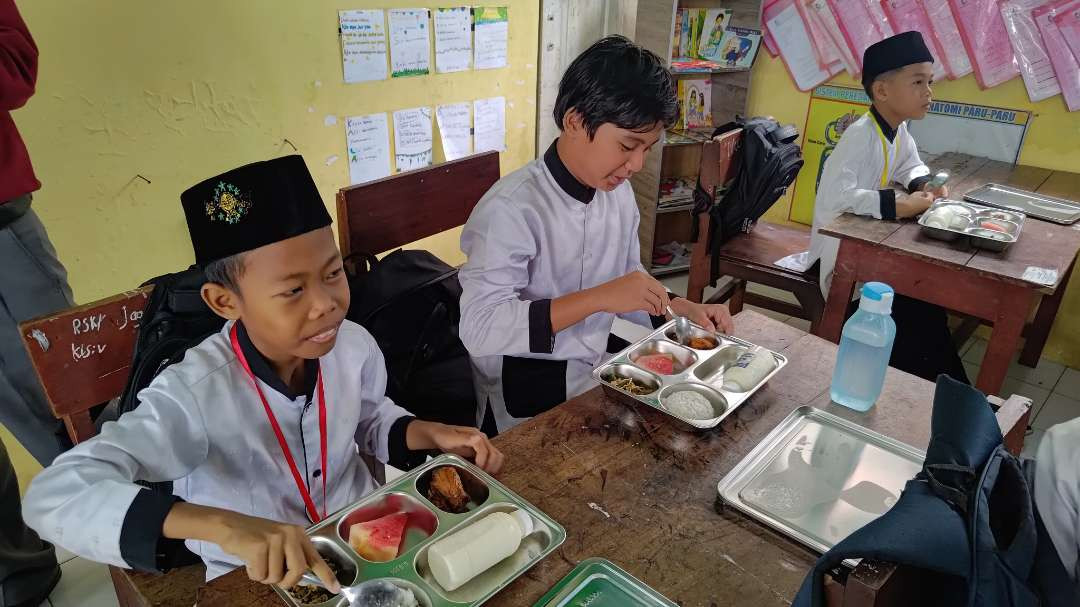 Murid-murid SD menikmati menu yang disajikan dalam uji coba makan bergizi gratis. (Foto: Humas Pemkab Banyuwangi)