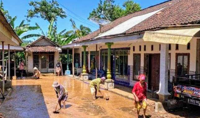 Warga Desa Sulek, Kecamatan Tlogosari Bondowoso membersihkan lumpur akibat banjir dan longsor, Senin 23 Desember 2024 pagi dini.(Foto: Guido Saphan/Ngopibareng.id)