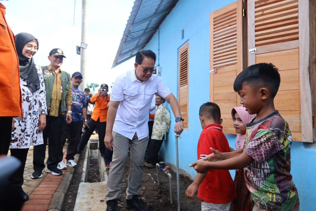 Pj Gubernur Jawa Timur, Adhy Karyono menyapa bocah dari keluarga penerima rumah hunian tetap korban banjir bandang Kalibaru. (Foto: Humas Pemkab Banyuwangi)