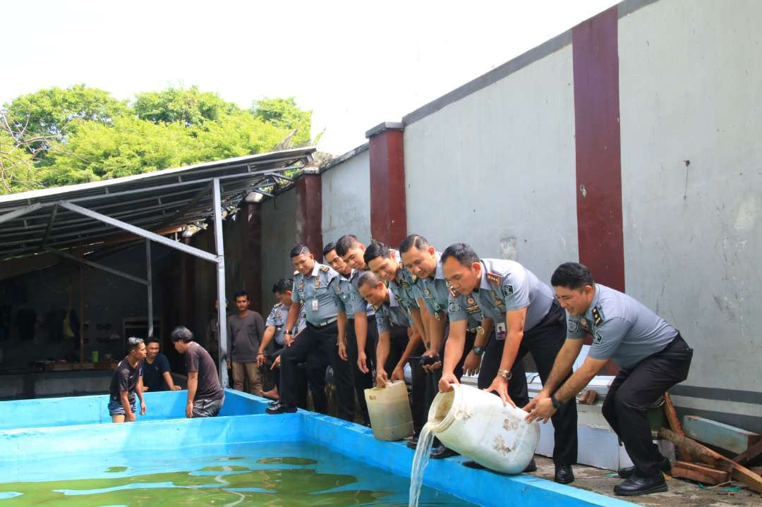 Pegawai Lapas Banyuwangi melepaskan bibit lele di kolam budidaya yang ada di dalam Lapas Banyuwangi (foto : Istimewa)