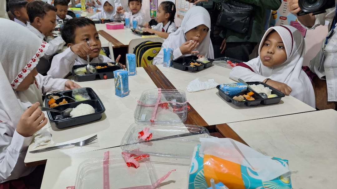 Siswa-siswi SD Negeri Klampis Ngasem III/512, Jalan Manyar Kertoarjo, Surabaya saat menikmati makan bergizi gratis (MBG), pada uji coba pemberian MBG, Kamis 1 Agustus 2024 silam. (Foto: Julianus Palermo/Ngopibareng.id)