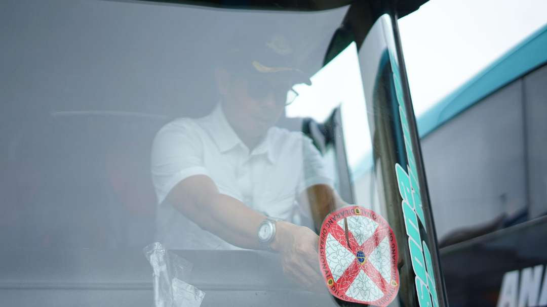 Petugas Dirjen Hubdat Kemenhub saat menempelkan stiker larangan operasi terhadap salah satu unit bus pariwisata yang tidak lolos monitoring dan rampcheck di Terminal Kawasan Wisata Religi Sunan Ampel, Surabaya. (Foto: Istimewa)